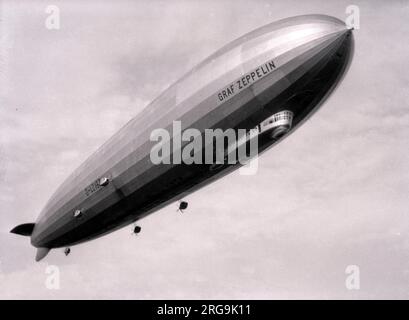 Das deutsche Luftschiff Graf Zeppelin D-LZ127 im Hanworth Air Park führt Sightseeing-Flüge über London durch. Am 18. August 1931 besuchte das deutsche Luftschiff Graf Zeppelin (D-LZ127) Hanworth. Am 2. Juli 1932 kehrte es im Rahmen einer Rundreise durch Großbritannien zurück und führte am nächsten Tag kostenpflichtige Flüge über London durch. LZ127 war einzigartig unter allen gewerblichen starren Luftschiffen, da es das einzige war, das ausschließlich einen gasförmigen Kraftstoff namens Blaugas verwendete. Blaugas war ein Gemisch aus Propylen, Methan, Acetylen, Butylen und Wasserstoff. Da Blaugas nur 9 % schwerer ist als Luft, wurde das Problem von Bedeutung durch die Verwendung von Blaugas beseitigt Stockfoto