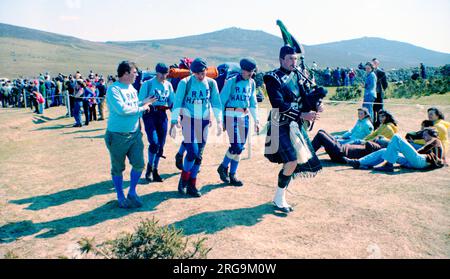 RAF Halton-Auszubildende treten im 1977. märz im Ten Tors-Cross-Country-Team an. - Ein 125.-Team marschiert rein, angeführt von Charles Chuck Kirkbride von der RAF Halton Pipe Band Stockfoto