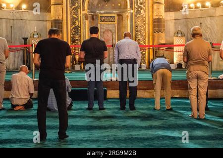 Istanbul, Türkei, Türkiye. Hagia-Sophia-Moschee. Männer beten, dem Mihrab gegenüber. Stockfoto
