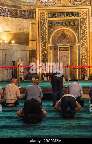 Istanbul, Türkei, Türkiye. Hagia-Sophia-Moschee. Männer beten, dem Mihrab gegenüber. Stockfoto
