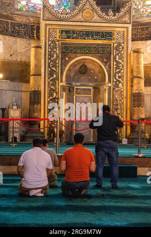 Istanbul, Türkei, Türkiye. Hagia-Sophia-Moschee. Männer beten, dem Mihrab gegenüber. Stockfoto