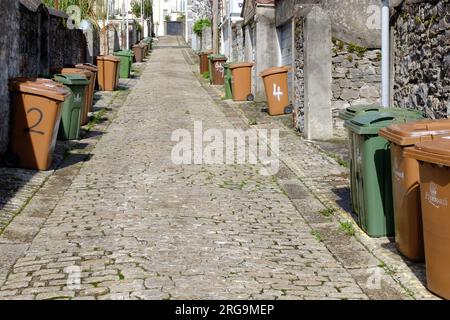 Recycling-Mülltonnen in einer gepflasterten Seitenstraße in Plymouth, Devon, England Stockfoto