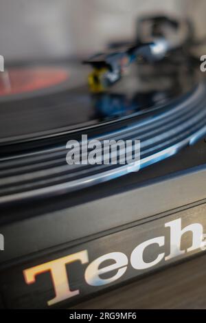 Close up Vinyl record playing spinning on Technics 1210 MK2 DJ Deck turntable with motion blur. Stock Photo