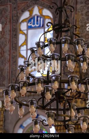 Istanbul, Türkei, Türkiye. Kronleuchter in der Neuen Moschee (Yeni Camii). „Allah“ im Fensterbereich. Stockfoto