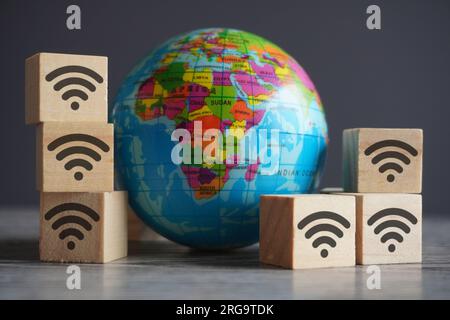 Nahaufnahme von Kugel und Holzwürfeln mit WLAN-Symbol. Internet und globales Netzwerkkonzept Stockfoto