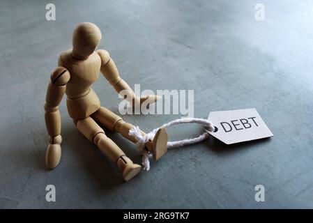 Hölzerne menschliche Figur und SCHULDVERSCHREIBUNGEN. Platz für Text kopieren. Finanzen, Schuldenlast-Konzept. Stockfoto