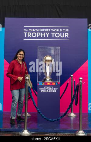 Dhaka, Bangladesch. 08. Aug. 2023. Ein Sportjournalist posiert für ein Foto neben der Trophäe der ICC Männer Cricket World Cup, die im Sher-e-Bangla National Stadium in Mirpur, Dhaka, ausgestellt wird. Die Trophäen-Tour zur ICC-Weltmeisterschaft der Herren in Bangladesch findet vom 07. Bis 09. August 2023 statt. Kredit: SOPA Images Limited/Alamy Live News Stockfoto