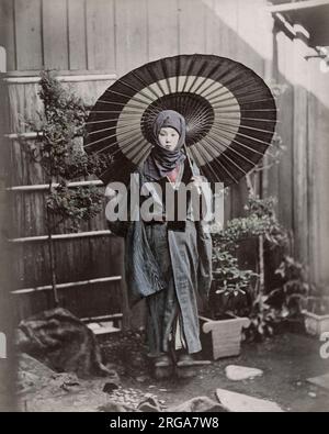 Junge Japanerin im Winterkostüm mit Regenschirm. Vintage 19. Jahrhundert Foto. Stockfoto