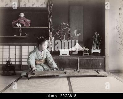 Junge Frau, die ein koto-Streichinstrument spielt, Japan. Vintage 19. Jahrhundert Foto. Stockfoto