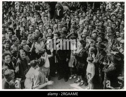 WW2 Uhr - um 3pm Uhr am 8. Mai 1945 - ein Bugler läutet den Waffenstillstand im Hotel de Ville, Paris, umgeben von feierlichen Parisern. Stockfoto