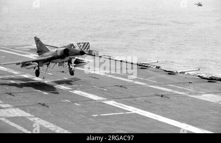 Aeronavale - Dassault-Breguet Super etendard '66' fängt den Draht an und landet an Bord von 'Foch' oder 'Clemenceau' während einer Kreuzfahrt. (Hinweis: Foch und Clemenceau waren zwei fast identische Schiffe, auf die die französische Marine keine Unterscheidungszeichen angebracht hatte, was die Identifizierung sehr schwierig machte.) Stockfoto