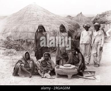 C 1880 Indien - Indien Dorf Gruppe - Männer und Frauen mahlen von Korn mit einem mühlstein Stockfoto