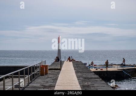 Caloura, Azoren, 19.09.2019 - Blick über den Pier und den kleinen Leuchtturm im Fischereihafen Caloura auf der Insel São Miguel auf den Azoren Stockfoto