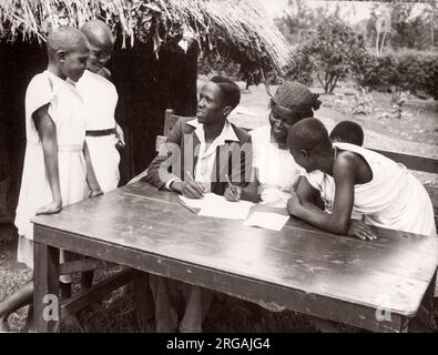 1940s Ostafrika - Kikiyu-Mädchen erhalten einen Brief, den der Sohn des Distriktchefs, Kenia, von einem während des Zweiten Weltkriegs in Ostafrika und im Nahen Osten stationierten Rekrutierungsbeamten der britischen Armee fotografiert hat Stockfoto