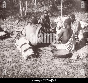 1940s Ostafrika - Uganda - Wanderarbeiter aus dem Kongo mit ihren Reisepaketen fotografieren einen während des Zweiten Weltkriegs in Ostafrika und im Nahen Osten stationierten britischen Rekrutierungsbeamten Stockfoto