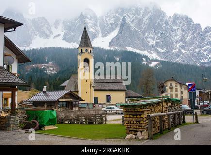 Frühling das Bergdorf Cima Sappada in Carnia in der Provinz Udine, Friaul-Julisch Venetien, Nordost-Italien. Die St. Oswald Kirche ist zentral gelegen Stockfoto