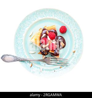 Scheibe Vanille-Käsekuchen mit Schokoladensoße, frischen Himbeeren und Mandeln auf dem Teller. Isoliert auf weißem Hintergrund, png Stockfoto