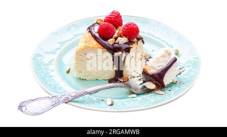Scheibe Vanille-Käsekuchen mit Schokoladensoße, frischen Himbeeren und Mandeln auf dem Teller. Isoliert auf weißem Hintergrund, png Stockfoto
