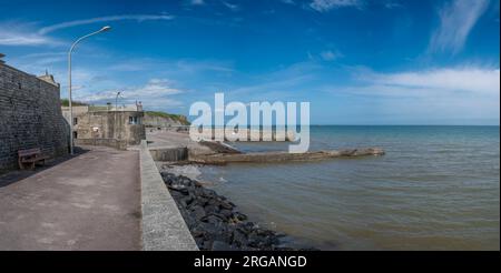 Arromanches-les-Bains, Frankreich - 07 20 2023: Blick auf die steinernen Anlegestelle und das Meer vom Strand Stockfoto