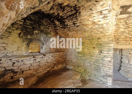 Blick von innen auf eine Steinhütte mit historischem Ofen in Village des Bories, Gordes, Luberon, Vaucluse, Provence, Frankreich Stockfoto