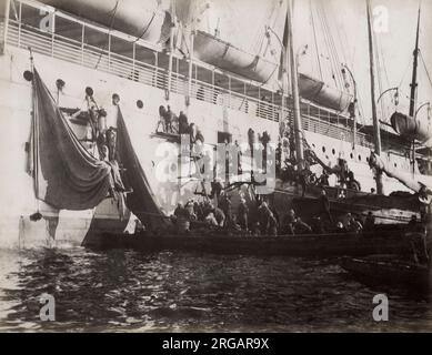 Vintage-Fotografie des 19. Jahrhunderts - Vorräte werden auf ein Ozeanschiff geladen, wahrscheinlich in einem asiatischen Hafen, um 1890. Stockfoto