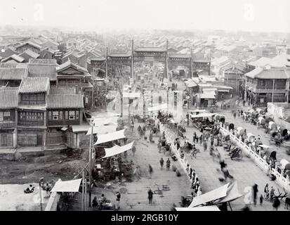 Foto des frühen 20th. Jahrhunderts: Paifang, Pailou, Bogen- und Straßenszene, Peking, Peking, China Stockfoto