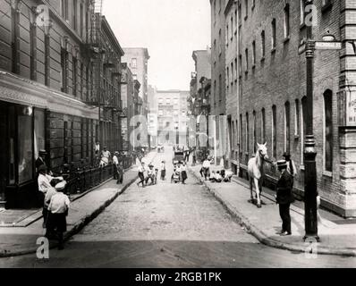 Im frühen 20. Jahrhundert vintage Pressefoto - Kinder spielen in der Straße auf Minetta Lane, Greenwich Village, Manhattan, New York, c 1920 s, Pferd im Vordergrund. Stockfoto