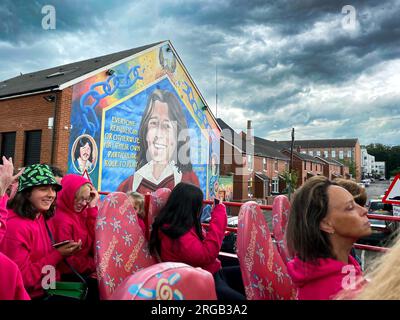 Leute im Tourbus in Belfast, Nordirland, halten an, um sich das Bobby Sands Wandbild in Belfast anzusehen Stockfoto