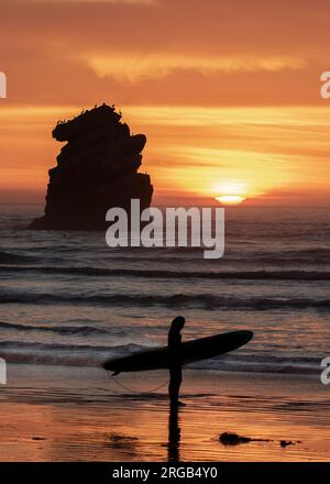 Surfer am Morro Bay Beach bei Sonnenuntergang. Stockfoto