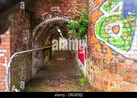 Der alte Pfad unter der Straßenbrücke über den Rochdale Canal in Ancoats Manchester. Stockfoto