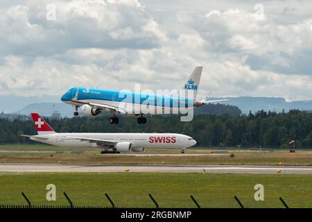 Zürich, Schweiz, 13. Juli 2023 PH-EXY KLM RoyalDutch Airlines Embraer E190-Std Flugzeug landet auf Landebahn 14 mit einem schweizer Flugzeug im Hintergrund Stockfoto