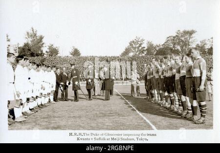 Prinz Heinrich Herzog von Gloucester und die „Garter Mission“ in Japan, um Kaiser Showa (Hirohito) (1901-1989) den Fremden Ritter des Hosenbandordens (KG) zu verleihen; 1929 übertragen, 1941 widerrufen, 1971 restauriert. Der Herzog und der Earl of Airlie inspizieren beide Seiten vor einem Fußballspiel zwischen der Besatzung seines Schiffes (HMS Suffolk) und Kwanto im Meiji-Stadion in Tokio. Stockfoto