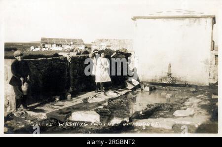 Moudros, Lemnos, Griechenland - Wäscherei im Freien - Wäsche waschen, indem man die Kleidung gegen große Steine reibt und dann über Wänden und Zäunen in der heißen Sonne trocknet. Stockfoto