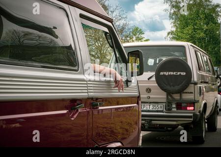 Entdecken Sie den Vintage-Charme deutscher Automobile auf der T3 Caravan Show 2023 in Hannover. 2 Transporter hintereinander, Fahrer hält die Hand aus dem Fenster Stockfoto