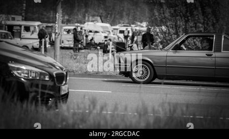 „Contrassting Eras: BMWs kollidieren in Hannovers Innenstadt – Eine eindrucksvolle Begegnung von Old Vintage Charme und modernem Stil Stockfoto