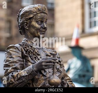 Royal Mile, Edinburgh, Schottland, Großbritannien, 8. August 2023. Edinburgh Fringe Street Performers: Eine lebende Statue der Wissenschaftlerin Marie Curie unterhält die vorbeiziehende Menge mit Kindern. Kredit: Sally Anderson/Alamy Live News Stockfoto