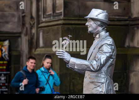 Royal Mile, Edinburgh, Schottland, Großbritannien, 8. August 2023. Edinburgh Fringe Street Performers: Eine lebende Statue, silberfarben gemalt, unterhält die vorbeiziehenden Massen. Kredit: Sally Anderson/Alamy Live News Stockfoto