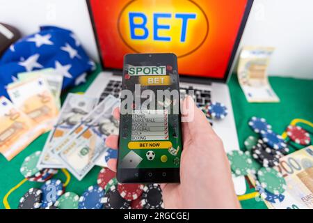 Schreiben Sie Ihre Wette gewinnt auf einem Smartphone auf dem Pokertisch. Wetten, Sportwetten, Buchmacher. Gemischte Medien. Stockfoto