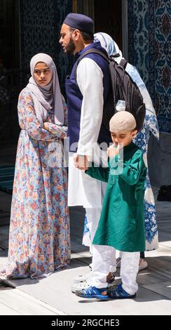 Istanbul, Türkei, Turkiye. Eyup Sultan Moschee, türkische Familie mit traditioneller Kleidung, Frau mit Hijab und Blumenmuster. Stockfoto