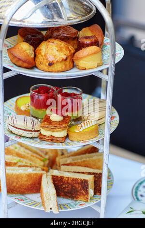 Auswahl an Sandwiches und feinen Kuchen, serviert für die Zeremonie des Nachmittagstees auf einem Kakestand Stockfoto