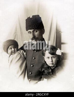 Ein Foto des Befehlshabers des 11. Kafkas-Regiments (3. Zug) mit seinen beiden Kindern. Die islamische Armee des Kaukasus (Türkisch: Kafkas Islam Ordusu) war eine militärische Einheit des Osmanischen Reiches, die am 10. Juli 1918 gebildet wurde. Der osmanische Kriegsminister Enver Pascha ordnete seine Einrichtung an und spielte eine wichtige Rolle während der Kaukasus-Kampagne des Ersten Weltkriegs Stockfoto