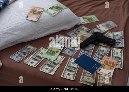 Geld und Waffen im Kriminallabor zur Untersuchung, konzeptuelles Image Stockfoto