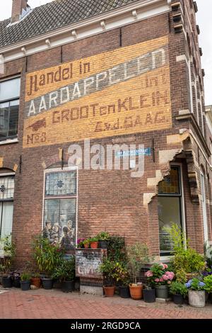 House (ehemaliger Kartoffelhandel) mit einer Kopie der Kartoffelesser von Vincent van Gogh, Delft, Niederlande Stockfoto