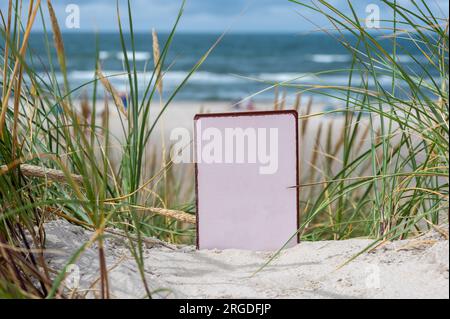 Leeres Whiteboard in den Sanddünen am Strand. Stockfoto