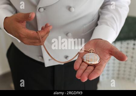 Ein Mann mit einer kostbaren antiken Taschenuhr. Stockfoto