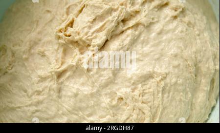 Frisch gekneteter Teig in einem Becken, frisch fermentierter Teig aus nächster Nähe, Stockfoto