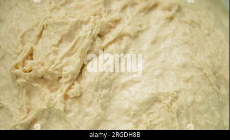 Frisch gekneteter Teig in einem Becken, frisch fermentierter Teig aus nächster Nähe, Stockfoto