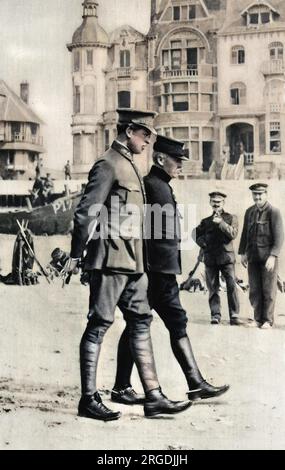 König Albert I. von Belgien und belgischer General Jules Marie Alphonse Jacques de Dixmude (1858-1928), der an einem kleinen belgischen Strand unter ruhenden Truppen spaziert. Der König trägt das neue Khaki, das er für seine Armee adoptiert hat. General Jacques und seine Truppen verhinderten, dass Dixmude im Ersten Weltkrieg in die deutschen Hände fiel, und wurden 1919 durch den Aufstieg zum Baron von Dixmude geehrt. Stockfoto