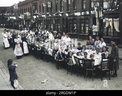 Friedensfeiern in London am Ende des Ersten Weltkriegs: Eine Teeparty in einer East End-Straße, sehr wahrscheinlich am 19. Juli 1919, dem Tag der Peace Day Victory Prozession. Stockfoto