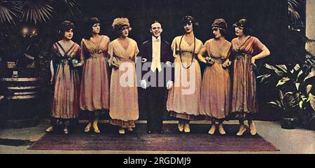 Les Rouges et Noirs, die Konzerttgruppe der Ersten Armee, wurde 1919 mit dem Manager, Captain Makeham, im Savoy Theatre fotografiert. Die Konzertparty der ersten Armee hieß Les Rouge et Noirs nach dem rot-schwarzen Schild der Einheit (ein schwarzer Streifen zwischen zwei roten Streifen). Das Ende des Krieges fand sie in der Gegend von Valenciennes, wo die nach dem Waffenstillstand im Stadttheater weiter auftraten. Die Besetzung wurde durch den Frühling demobiert und als Splittertruppe in England in My 1919 reformiert, und begann eine bemerkenswerte Karriere, die zumindest bis zum Ausbruch von WW2 fortgesetzt wurde. Stockfoto